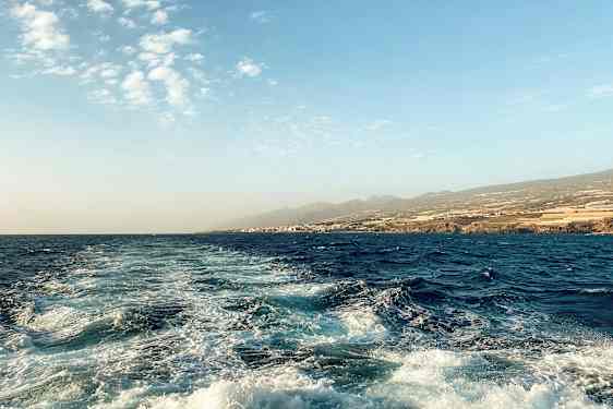 Meri maisema, jossa aaltoja ja rantaviivaa taustalla. (Tekoälyn luoma teksti)