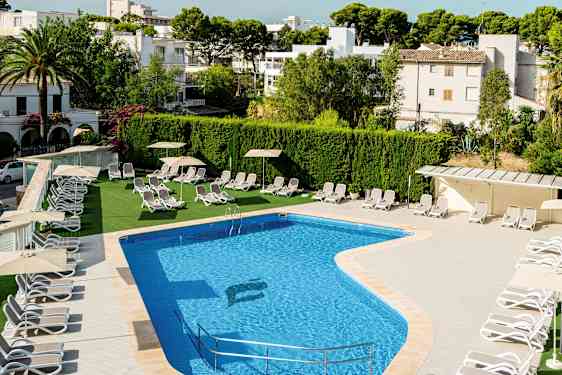 Ulkouima-allas, jonka vieressä on aurinkotuoleja ja varjoja, ympäröitynä vehreydellä ja rakennuksilla. (Tekoälyn luoma teksti)