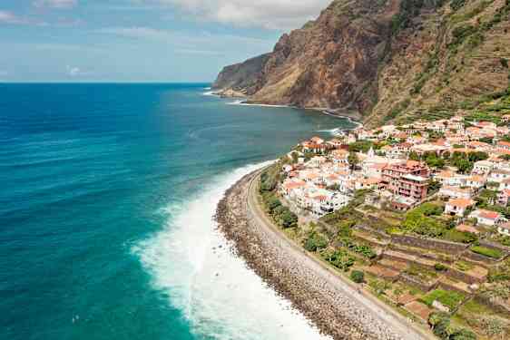 Näkymä rannikkoviivalle, jossa kylä sijaitsee kallion päällä ja taustalla on meri. (Tekoälyn luoma teksti)