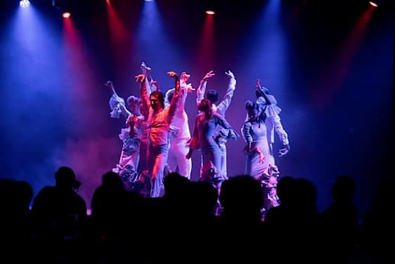 Tanssijat esittävät koreografiaa lavalla värivalojen loisteessa. (Tekoälyn luoma teksti)