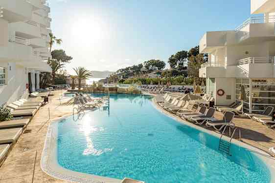 Ulkouima-allas, jonka ympärillä on aurinkotuoleja, hotellin yhteydessä aurinkoisella säällä. (Tekoälyn luoma teksti)