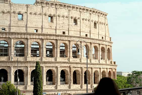 Kuva Rooman Colosseumista, Italiassa, etualalla oleva nainen. (Tekoälyn luoma teksti)