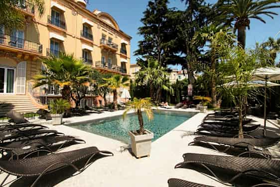 Ulkouima-allas hotellin luona, ympäröitynä palmuilla ja aurinkotuoleilla. (Tekoälyn luoma teksti)