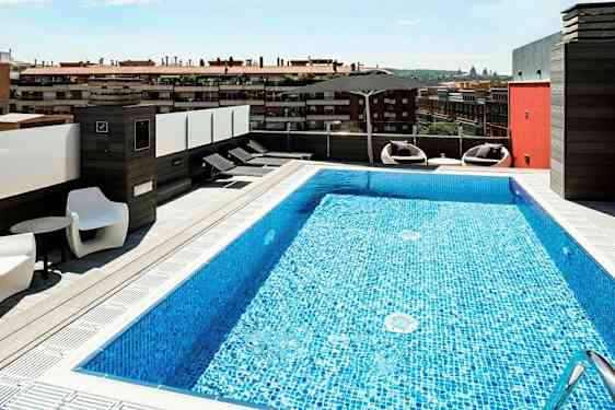 Kattoterassi, jossa uima-allas ja aurinkotuoleja, näkymä kaupunkiin. (Tekoälyn luoma teksti)