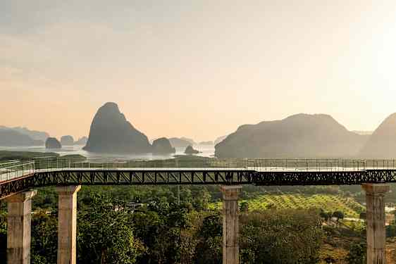 Sillan pylväät johtavat vesialueelle, taustalla vuoria. (Tekoälyn luoma teksti)