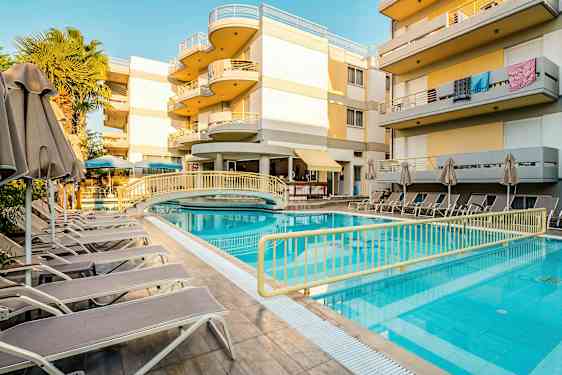 Ulkouima-allas, jonka ympärillä on aurinkotuoleja ja varjoja modernin rakennuksen vieressä. (Tekoälyn luoma teksti)