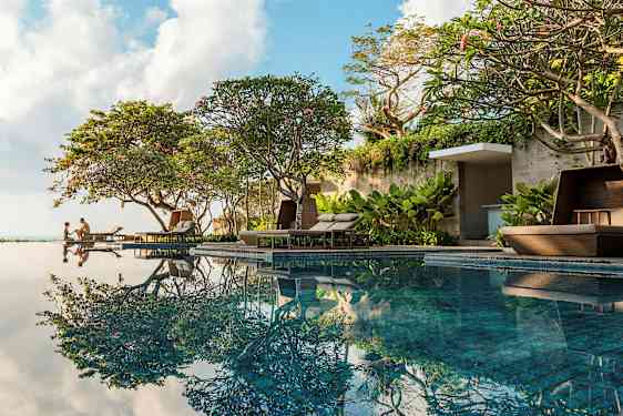 Uima-allas vehreiden puiden ja mukavien aurinkotuolien äärellä. (Tekoälyn luoma teksti)