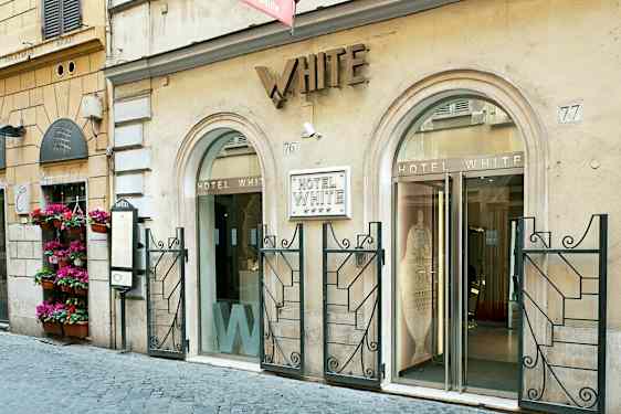 Hotel White -sisäänkäynti, rakennus, jossa on kaksi lasiovea ja koristeltu julkisivu. (Tekoälyn luoma teksti)