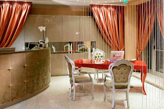 Vastaanottotila, jossa on punainen pöytä, tyylikkäät huonekalut ja koristeellisia elementtejä. (Tekoälyn luoma teksti)