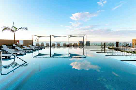 Infinity-allas aurinkotuoleilla ja näköala merelle. (Tekoälyn luoma teksti)