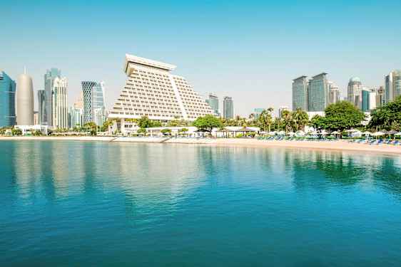 Kuva kaupungista, jossa on modernia arkkitehtuuria rauhallisen rannan ja veden äärellä. (Tekoälyn luoma teksti)