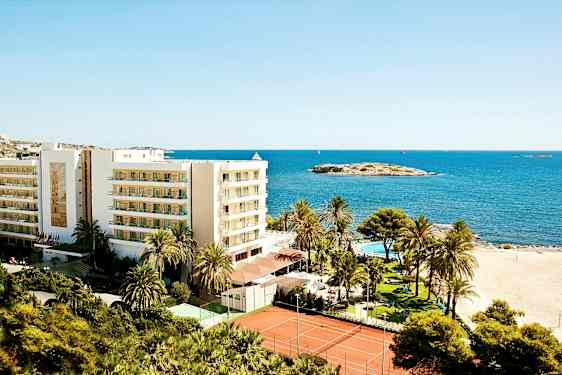 Kuva lomakeskuksesta rannalla, jossa rakennus, palmuja, uima-allas ja tenniskentät meren äärellä. (Tekoälyn luoma teksti)