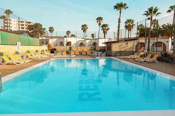 Ulkouima-allas, jossa aurinkotuoleja ja palmuja taustalla. (Tekoälyn luoma teksti)