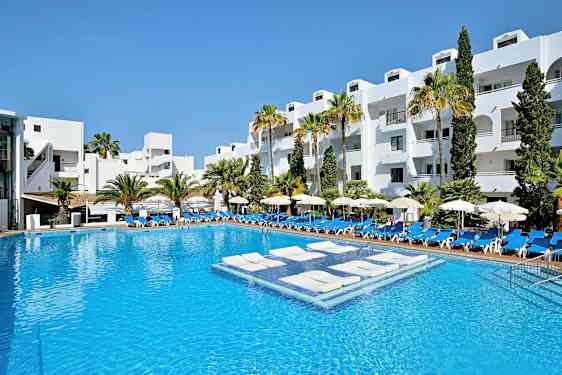 Hotellin uima-allas, taustalla valkoiseksi maalattuja rakennuksia ja palmuja. (Tekoälyn luoma teksti)