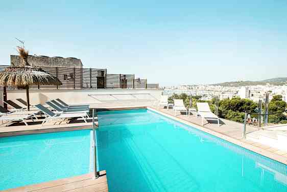 Uima-allas terassilla, jossa aurinkotuoleja ja näkymä kaupunkiin. (Tekoälyn luoma teksti)