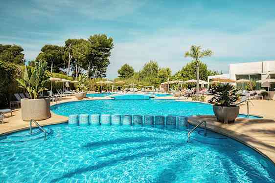 Ulkouima-allas aurinkotuoleilla ja aurinkovarjoilla sekä ympäröivää vehreyttä. (Tekoälyn luoma teksti)