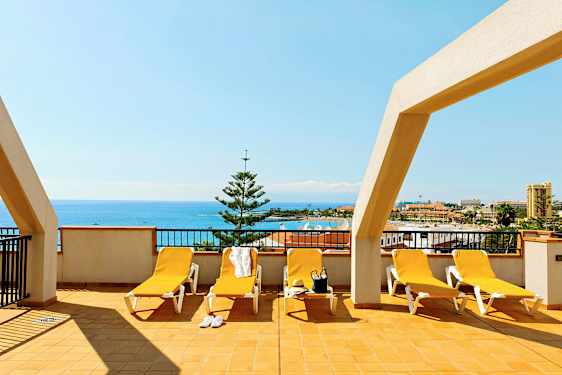 Terassi, jossa aurinkotuoleja ja merinäköala. (Tekoälyn luoma teksti)