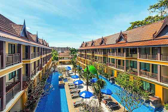 Kaksikerroksiset hotellirakennukset, joissa on viistot katot, ympäröivät altaan aurinkotuoleineen ja varjoineen. (Tekoälyn luoma teksti)