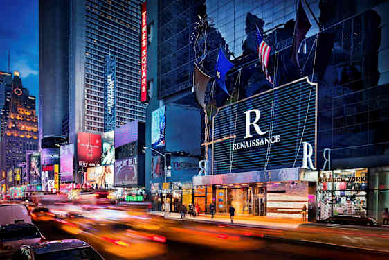 Kaupunkimaisema korkeilla rakennuksilla ja neonvaloilla. (Tekoälyn luoma teksti)