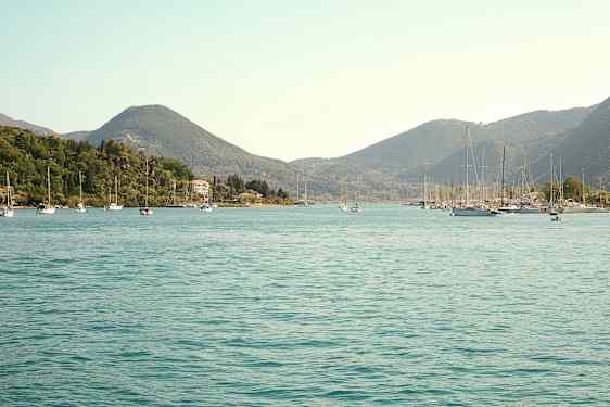 Näkymä lahdelle, jossa purjeveneitä ja ympärillä vehreitä kukkuloita. (Tekoälyn luoma teksti)