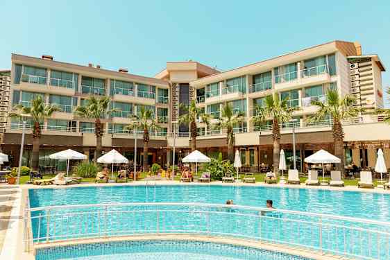 Hotellinäkymä uima-altaalla, aurinkotuoleilla ja varjoilla. (Tekoälyn luoma teksti)