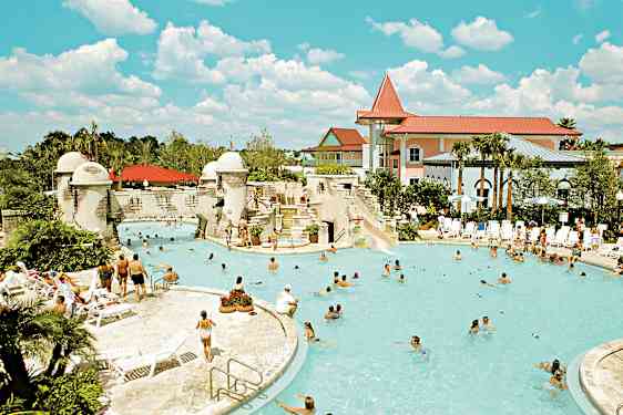 Ulkouima-allas, jota ympäröivät ihmiset, aurinkotuolit ja rakennukset. (Tekoälyn luoma teksti)