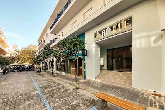 Katumaisema, jossa kauppoja ja kahviloita kivetyllä kävelytiellä. (Tekoälyn luoma teksti)