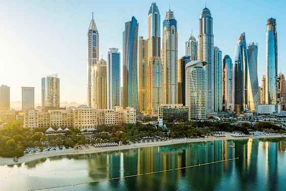 Kaupunkinäkymä, jossa korkeita rakennuksia ja ranta veden äärellä etualalla. (Tekoälyn luoma teksti)