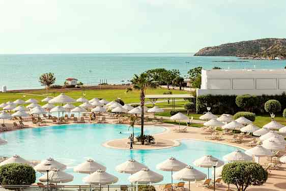 Uima-allas, jossa aurinkotuoleja ja varjoja, näkymät merelle ja vehreään ympäristöön. (Tekoälyn luoma teksti)