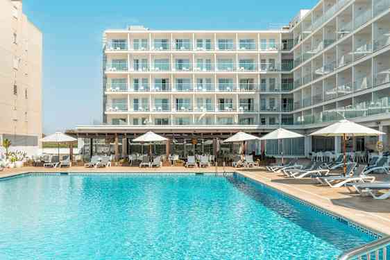 Rakennus, jossa on useita parvekkeita, uimallas edessä aurinkotuoleineen ja aurinkovarjoineen. (Tekoälyn luoma teksti)