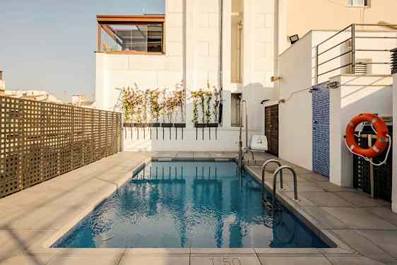 Ulkouima-allas, jota ympäröi terassi, jossa on seinällä kasvikoristeita. (Tekoälyn luoma teksti)