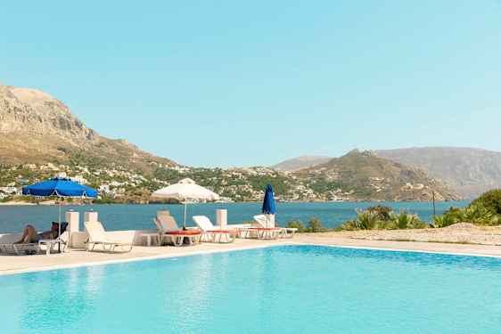 Ulkouima-allas, aurinkotuoleja ja aurinkovarjoja, sekä näkymä merelle ja vuorille. (Tekoälyn luoma teksti)