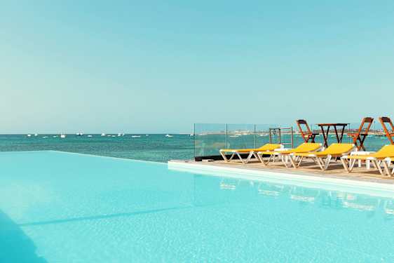 Uima-allas, jonka näköala avautuu merelle, ja aurinkotuoleja sen sivulla. (Tekoälyn luoma teksti)