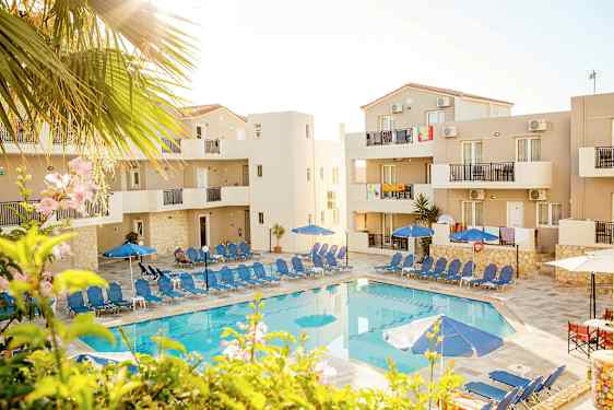 Kuva uima-altaasta, jota ympäröivät aurinkotuolit ja aurinkovarjot rakennusten keskellä. (Tekoälyn luoma teksti)