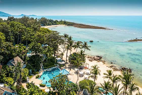 Trooppinen maisema, jossa on palmujen reunustama ranta ja kirkas sininen vesi. Etualalla on uima-allas ja vehreitä alueita. (Tekoälyn luoma teksti)