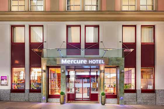 Mercure-hotellin sisäänkäynti, jossa kyltti ja julkisivu. (Tekoälyn luoma teksti)