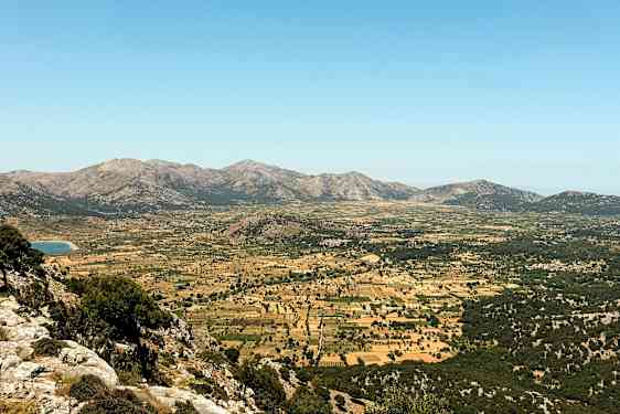 Laaja laakso, jota ympäröivät vuoret, laitumet ja viljelysmaat. (Tekoälyn luoma teksti)