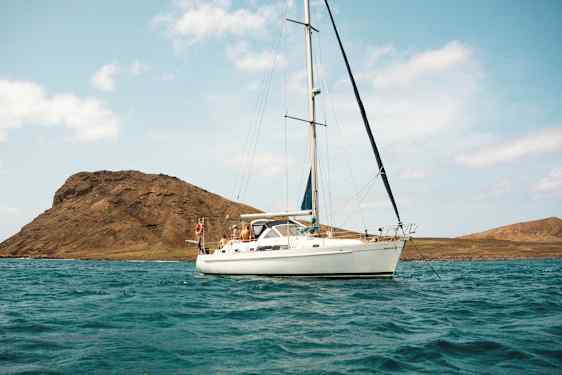 Purjevene vedessä, taustalla vuoria. (Tekoälyn luoma teksti)