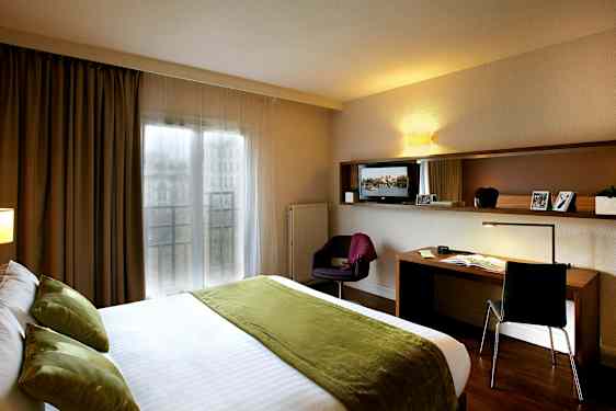 Hotellihuone, jossa parivuode ja työpöytä. (Tekoälyn luoma teksti)