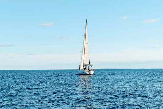 Purjevene purjehtii avoimella merellä kirkkaan taivaan alla. (Tekoälyn luoma teksti)