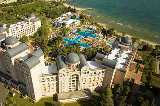 Ylhäältä kuvattu näkymä hotellikompleksista, jossa on uima-altaita ja ranta. (Tekoälyn luoma teksti)
