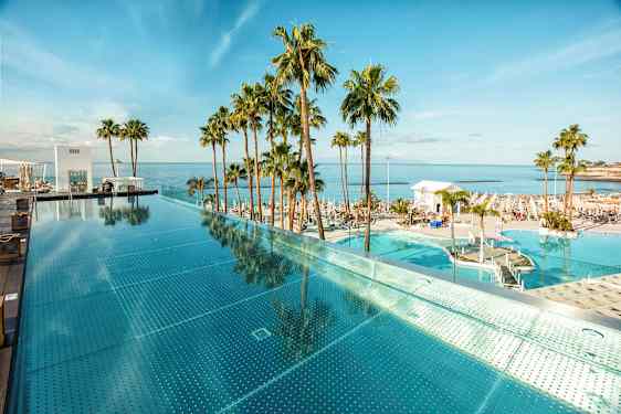 Infinity-allas meren äärellä, ympärillä palmuja. (Tekoälyn luoma teksti)