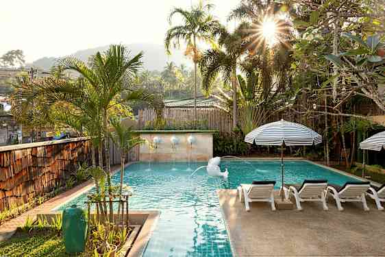 Aurinkoisen altaan ympärillä palmuja ja aurinkotuoleja. (Tekoälyn luoma teksti)