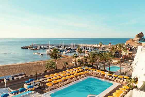 Näkymä uima-altaalle ja rannalle, taustalla satama. (Tekoälyn luoma teksti)