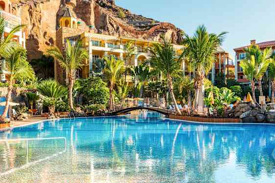 Uima-allas, jota ympäröivät palmut ja lomahuoneistot. (Tekoälyn luoma teksti)