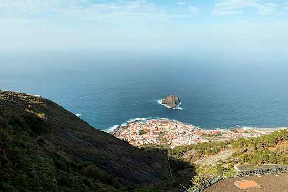 Näkymä rannikkokaupunkiin, taustalla meri ja kallio, nähtynä korkeuksista. (Tekoälyn luoma teksti)