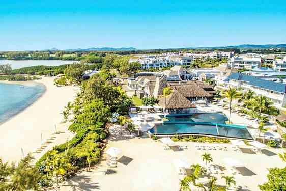 Ilmakuva lomakeskuksesta hiekkarannalla palmuineen ja uima-altaineen. (Tekoälyn luoma teksti)