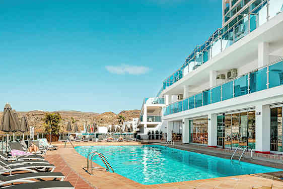 Uima-allasalue hotellin yhteydessä aurinkotuoleineen ja aurinkovarjoineen. (Tekoälyn luoma teksti)