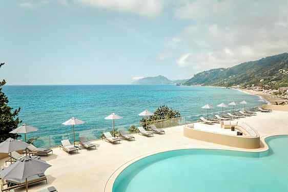 Näkymä altaasta ja merestä, jossa aurinkotuoleja ja aurinkovarjoja terassilla. (Tekoälyn luoma teksti)