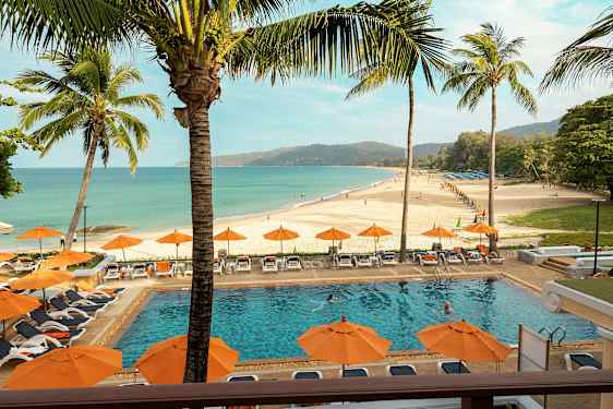 Ranta, jossa on uima-allas etualalla ja aurinkotuoleja ja varjoja ympärillä. (Tekoälyn luoma teksti)